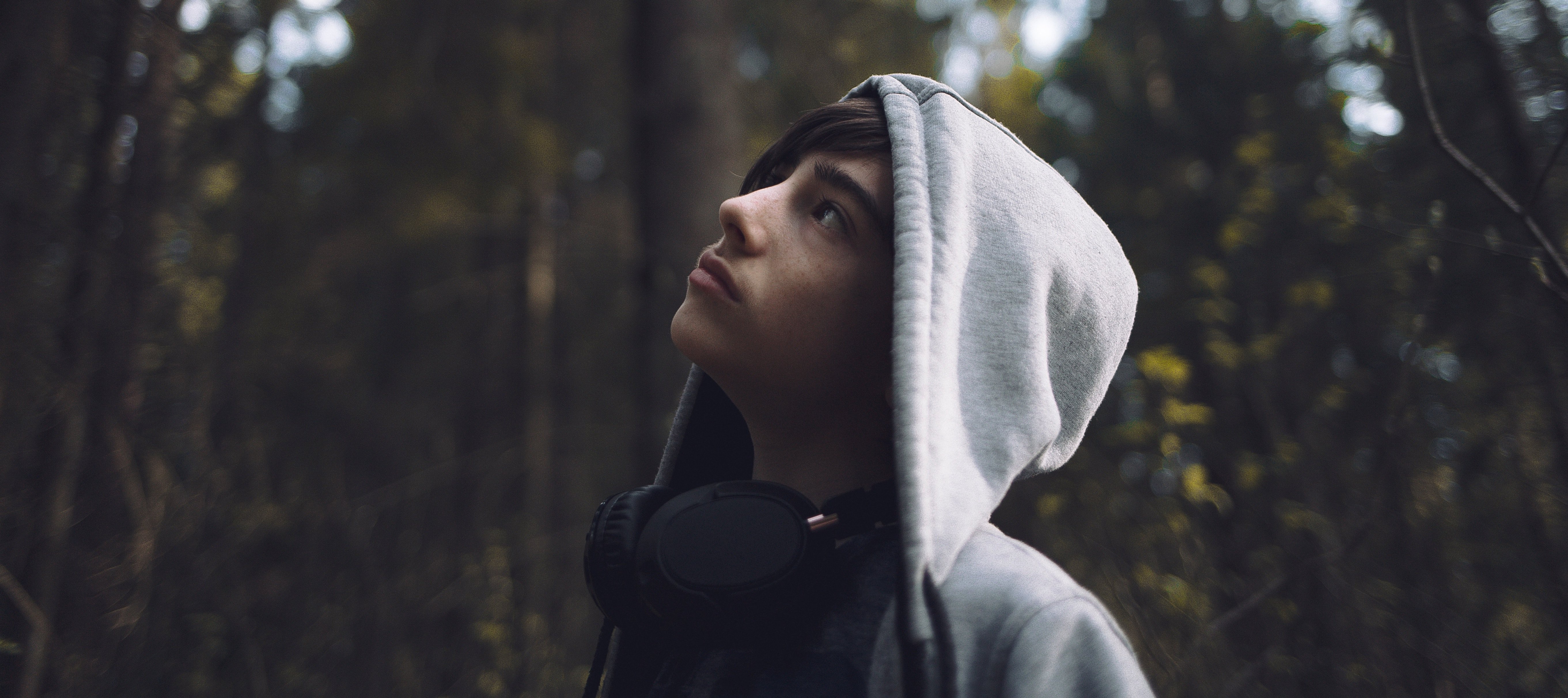 adolescent teenager with headphones looking up